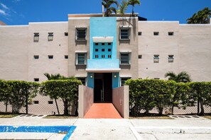 A building with a central blue section, multiple windows, and a red pathway leading to the entrance. - Walk to the Beach! Quiet Resort Retreat in Maunabo (Maunabo)