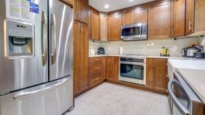 A kitchen with wooden cabinets, stainless steel appliances, and a built-in microwave. - 5 Mi to Kansas City Stadium! Bright Home w/ Yard (Kansas City)