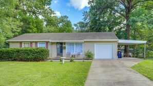 A single-story house with a front garage, a covered porch, and a well-maintained lawn. - 5 Mi to Kansas City Stadium! Bright Home w/ Yard (Kansas City)