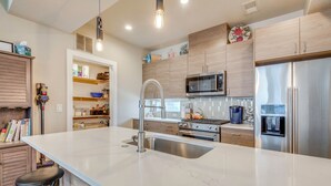 A modern kitchen with a large island, stainless steel appliances, and wooden cabinetry. - Walk to Mile High Stadium: Denver Home w/ Deck (Denver)