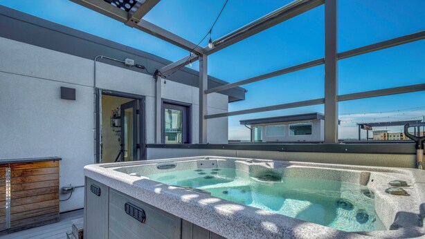 A hot tub on a deck with a clear view of the sky and a building in the background. - Walk to Mile High Stadium: Denver Home w/ Deck (Denver)