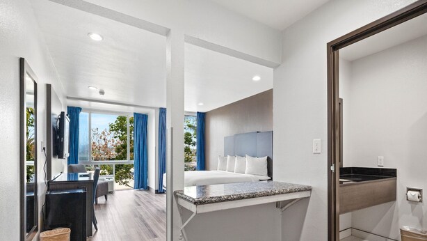 Une chambre d’hôtel moderne équipée d’un lit, d’un bureau et d’une salle de bain.