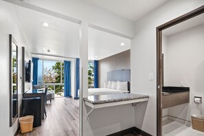Ein modernes Hotelzimmer mit Bett, Schreibtisch und Bad.