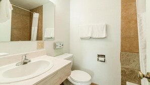 A bathroom with a sink, toilet, and shower curtain.