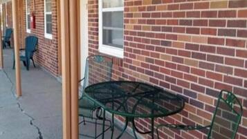 A row of brick buildings with outdoor seating areas, including tables and chairs.