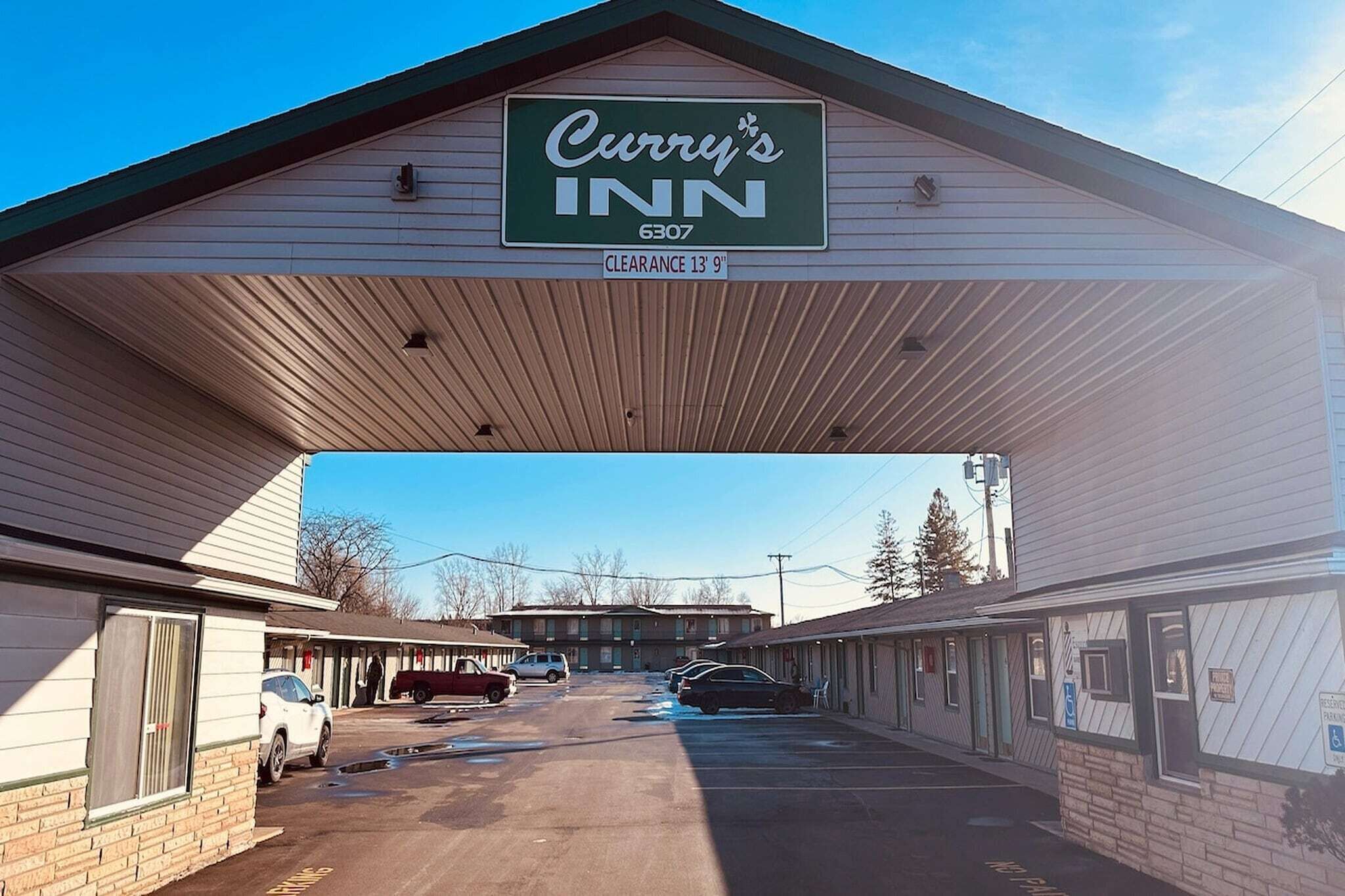 A Curry's INN with a clear 13'9' entrance, a parking lot, and a row of motel rooms.
