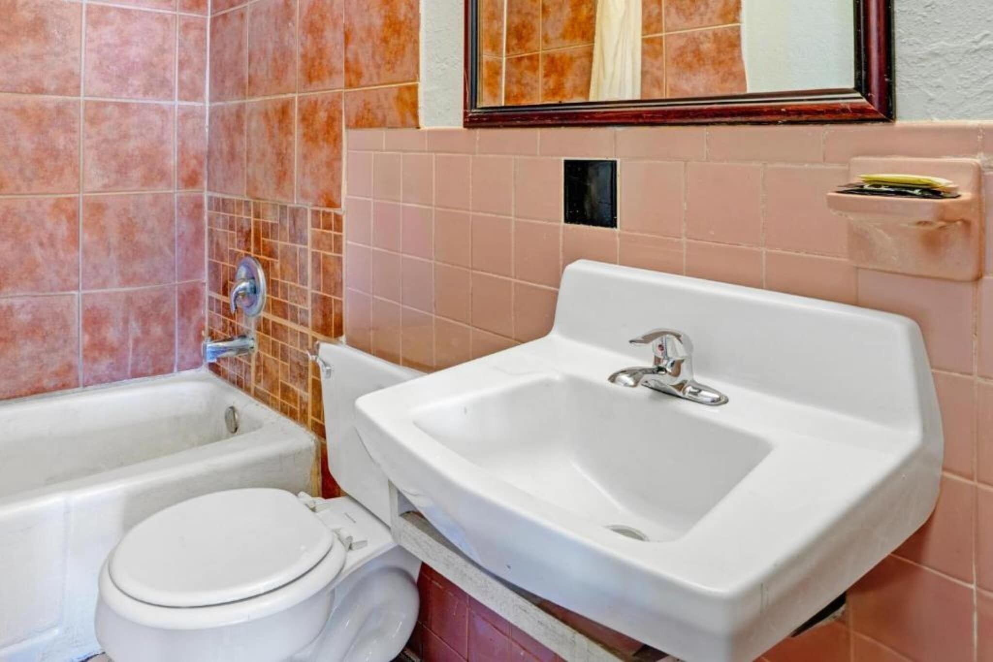 A bathroom with a bathtub, toilet, and sink.