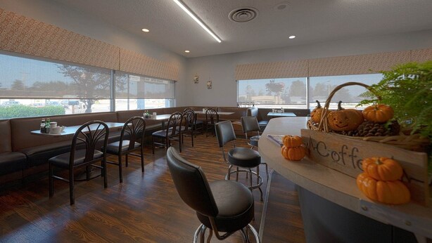 A restaurant with a long counter, booths, and a view of the city.