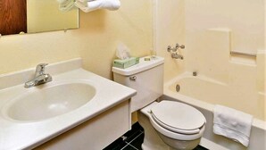Une salle de bain avec un lavabo, des toilettes et une baignoire.