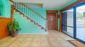 Eine Treppe mit Holzgeländer, einem Blumentopf und einem gemusterten Boden.