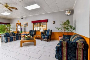 Uma sala de estar ampla, com sofás, uma mesa de centro e um ventilador de teto.