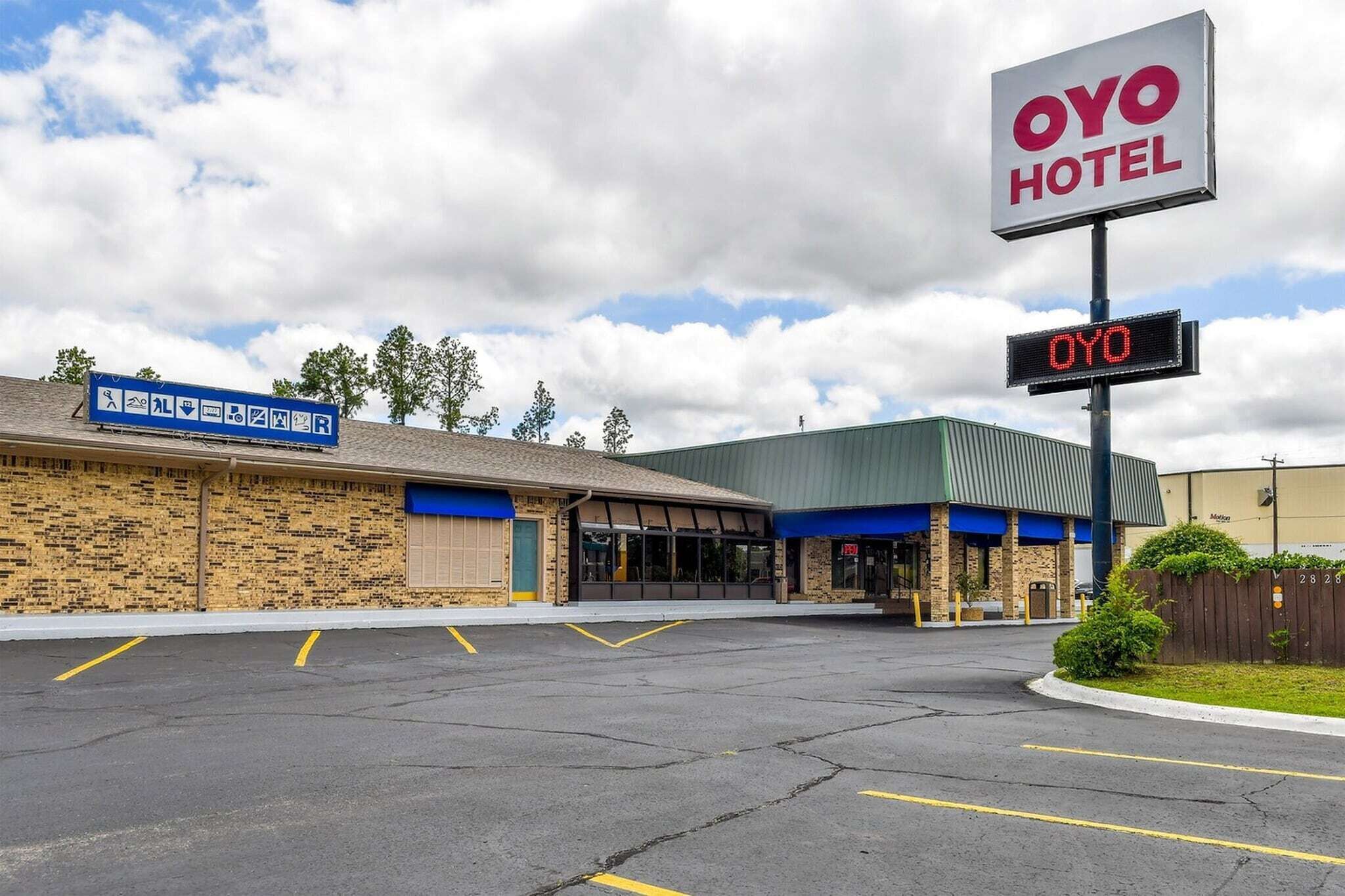 OYO Hotel med parkeringsplads, skilt og digital skærm.
