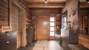 Een houten interieur met een deur, kasten en een spiegel.