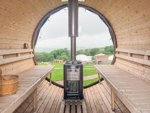A wooden sauna with a central chimney, benches, and a view of the surrounding landscape. - Boulsworth Hill Dome - UKC9596 (Clitheroe and the Ribble Valley)