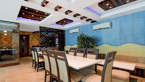 A modern dining area with a long table, chairs, and a decorative wall. - Classic With Balcony Hotel Coral (Kanthi)