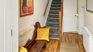 Una escalera de madera con barandilla que conduce a una puerta blanca.
