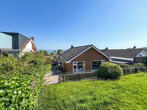 A residential area with houses, a grassy field, and a clear sky. - 3 bedroom accommodation in Paignton (Paignton)