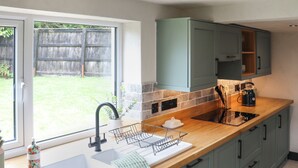 Een keuken met een spoelbak, aanrecht en kastjes.
