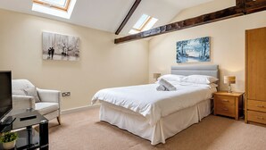 A bedroom with a bed, a chair, a TV, and artwork on the walls. - 2 bedroom accommodation in Barnard Castle (Barnard Castle)