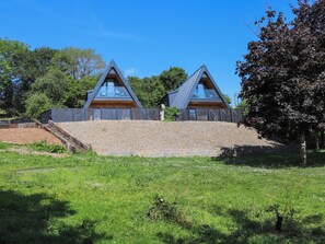 A modern house with a triangular roof and a large glass window. - 2 bedroom accommodation in Pen-Y-Felin, near Mold (Pen-Y-Felin, near Mold)