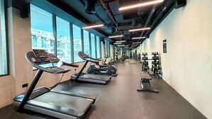 Ett gym med löpband, styrketräningsmaskiner och hantlar.