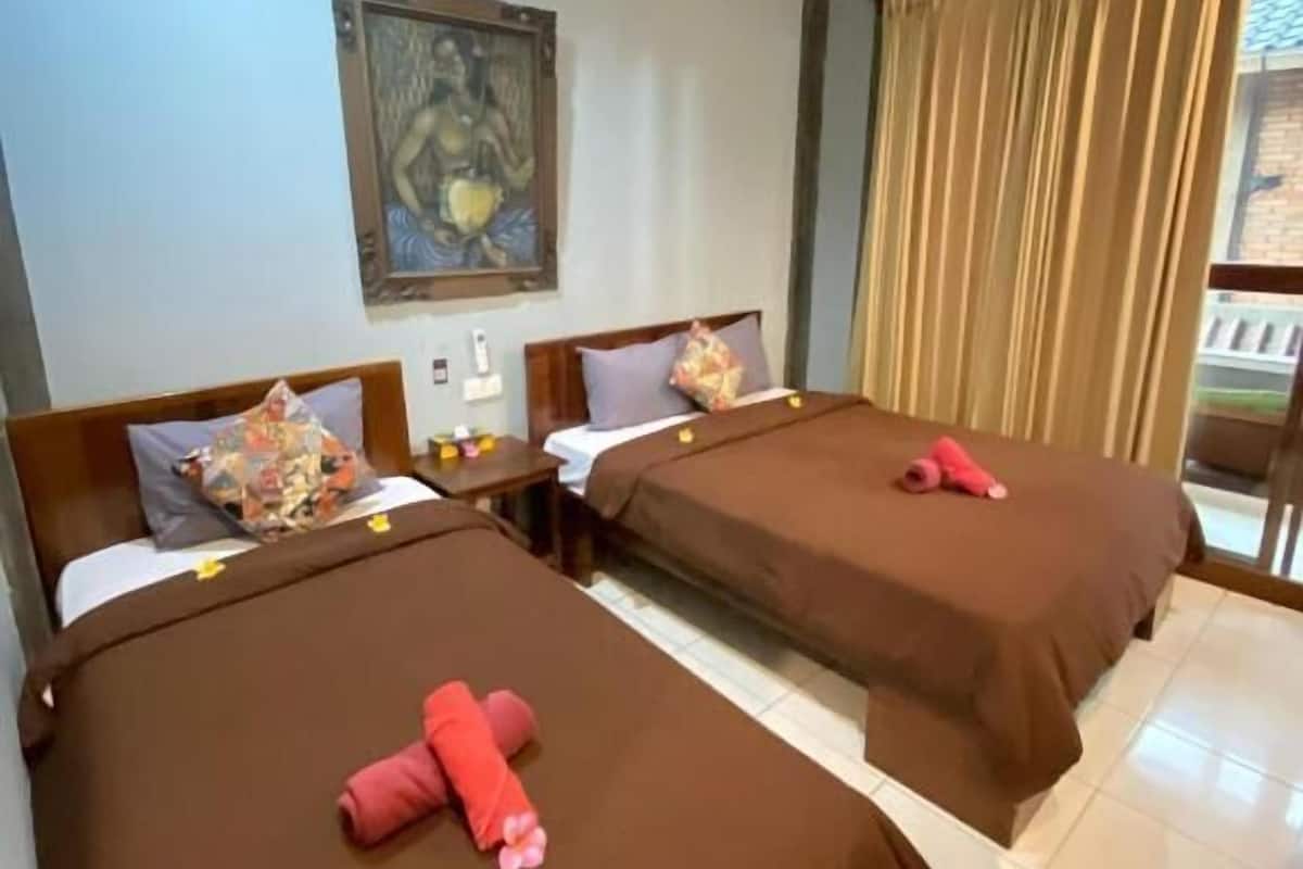 Una habitación de hotel con dos camas, un cuadro en la pared y una ventana con cortinas.
