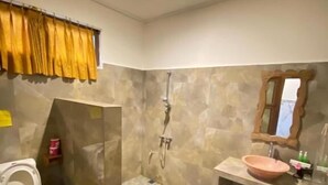 A bathroom with a toilet, shower, and sink.
