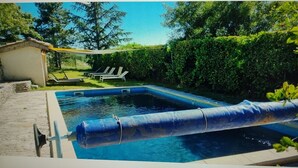A swimming pool with a slide, surrounded by greenery and a small shed. - Les Pierres Séches Vacation Rental, Les Andrieux 4/5 Banon (Banon)