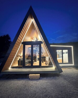 Un edificio moderno de forma triangular con entrada de vidrio y un interior visible con mobiliario.