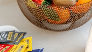 Uma tigela de frutas com morangos, kiwi, abacaxi e laranjas.