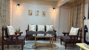 A living room with a sofa, two armchairs, a coffee table, and decorative wall art.