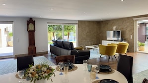 Een eetgedeelte met een tafel voor vier personen, een bank en gele stoelen.