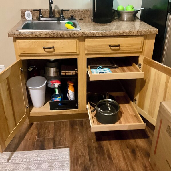 A kitchen with a sink, countertop, wooden cabinets, and a built-in oven.