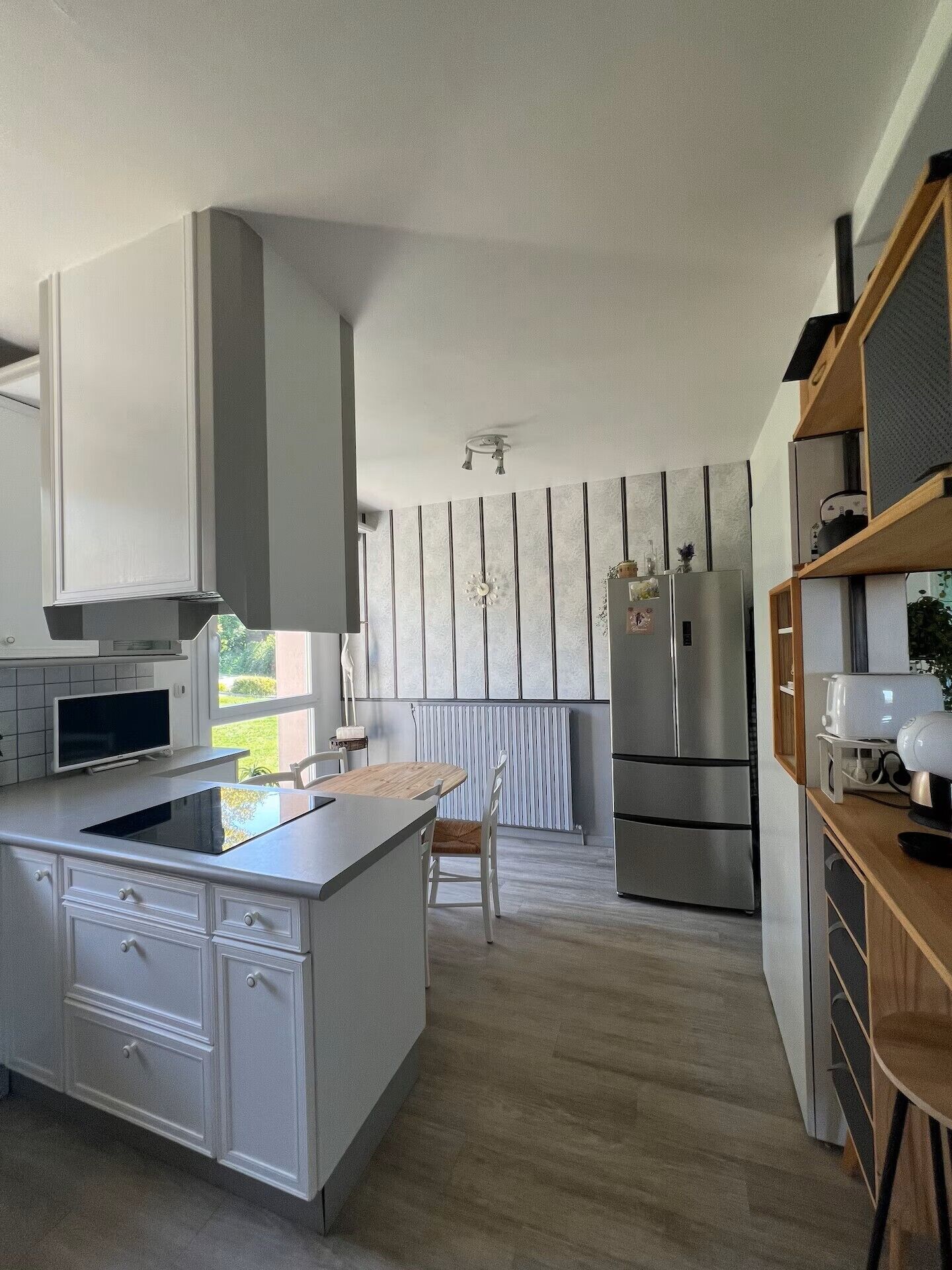 A modern kitchen with a central island, built-in appliances, and a view of the outdoors.