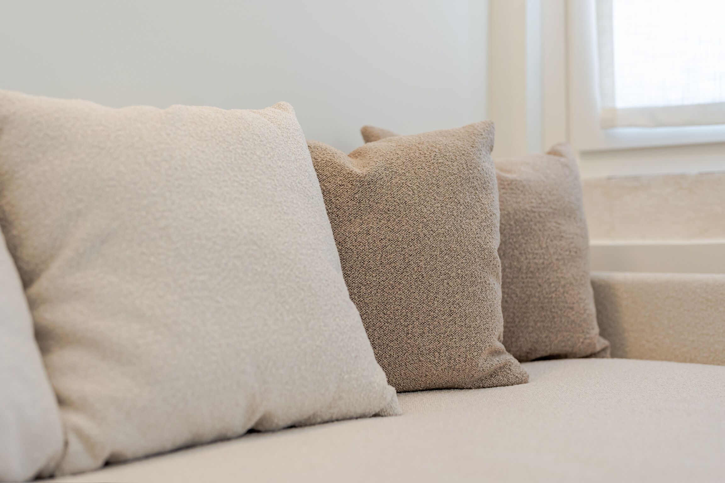 A sofa with three cushions.