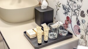A tray with toiletries and a glass of water on a countertop. - Garibaldi Luxury Suites - Graecalis (Noci)