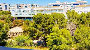 A coastal residential area with modern buildings, dense greenery, and a clear sky. - Stunning 3-bedroom apartment with a pool – Ideally located in La Zenia! (Orihuela)
