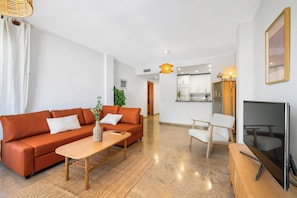 Ein modernes Wohnzimmer mit Sofa, Couchtisch und TV-Möbel.