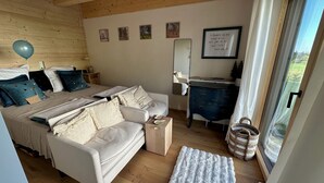 A bedroom with a bed, a sofa, a desk, a mirror, and a window. - Villa Barka – 5-Star Vacation Rental in the Bavarian Forest Near the National Park (Eppenschlag)