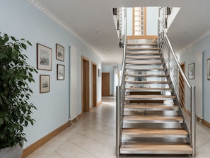 Eine moderne Treppe mit Metallgeländer und Holzstufen, die zu einer oberen Etage führt.