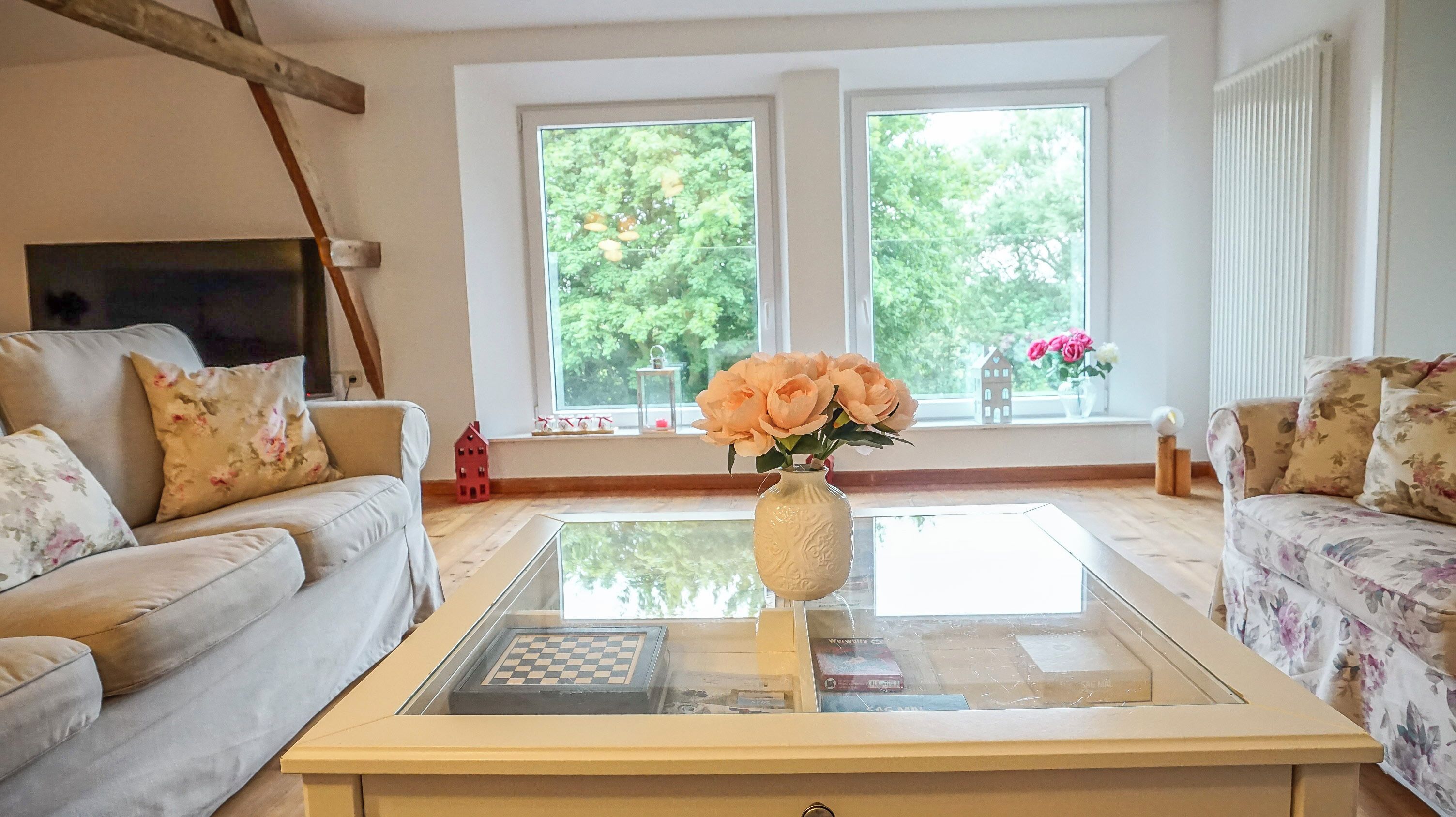 Ein Wohnzimmer mit zwei Sofas, einem Couchtisch und einer Blumenvase.