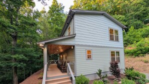 A two-story house with a covered porch and a staircase leading to the entrance. - Mountain Breeze (Bryson City)