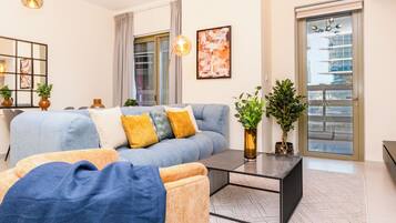 A modern living room with a sofa, coffee table, and potted plants.