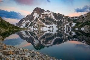 Un lac de montagne dont les eaux reflètent clairement les montagnes environnantes.