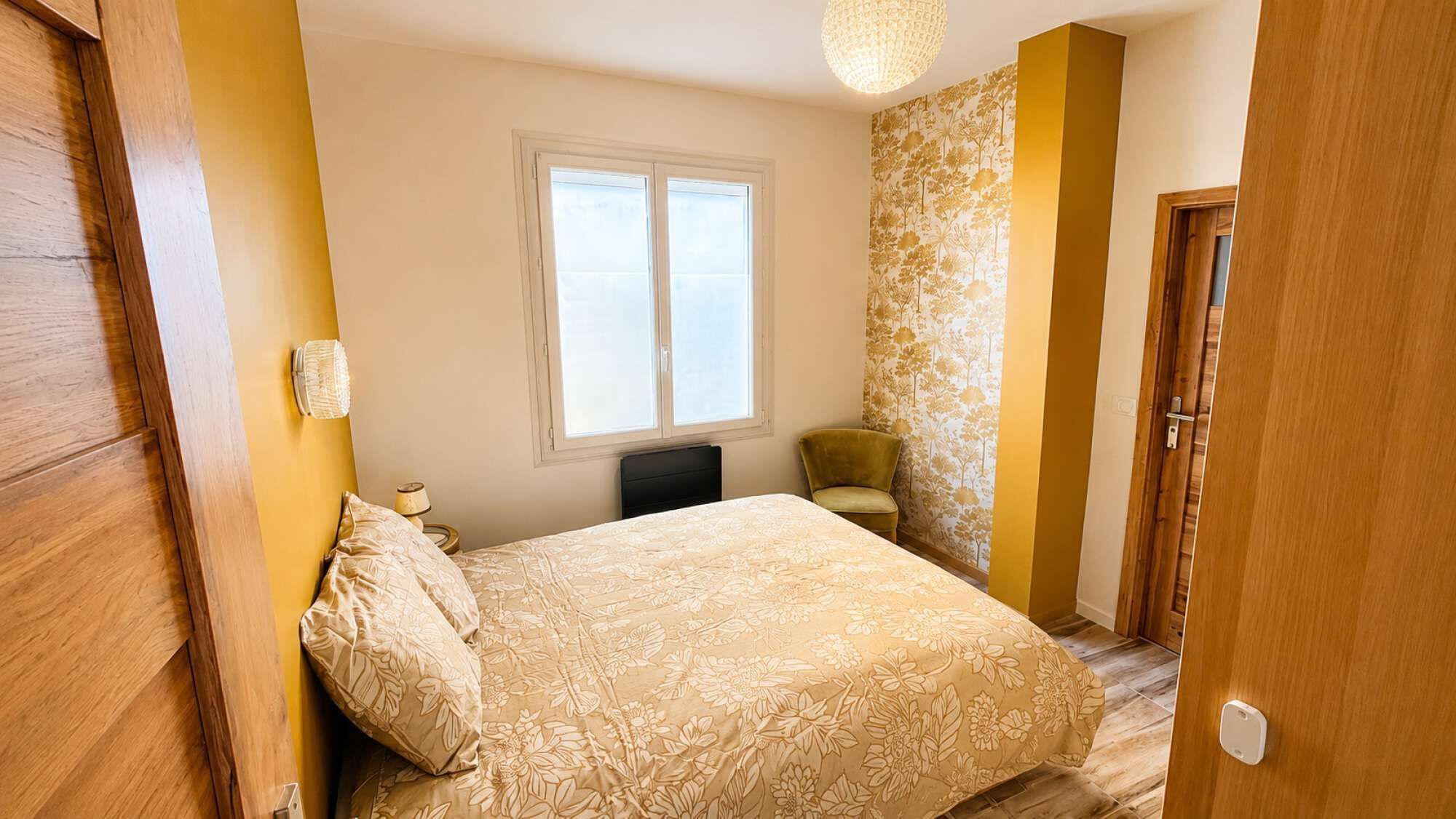 Ein Schlafzimmer mit Bett, Fenster, Stuhl und Tür.