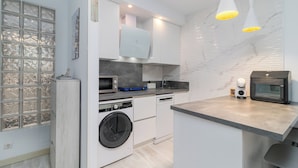 A modern kitchen with built-in appliances, a washing machine, and a microwave. - Modern apartment in downtown Somo. 3 minutes from the beach. (Somo)