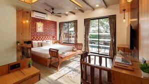 A bedroom with a bed, desk, chair, and a view of the outdoors. - Sunflower Vista - 6BR Estate with Pool, Hot Tub & Hill Views, Mahabaleshwar (Panchgani)