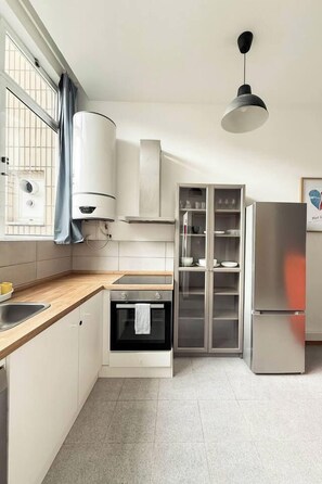 A modern kitchen with a built-in oven, a stainless steel refrigerator, and a glass-fronted cabinet. - 2Stay Porto – Affordable Accommodations for Everyone (Porto)