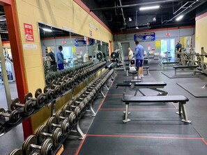 Ein Fitnessstudio mit Gewichtsbänken, Trainingsbänken und Trainingsgeräten.