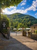 Una entrada con portón a una propiedad con un letrero que indica que ofrece hospedaje con desayuno, vino y patrimonio.